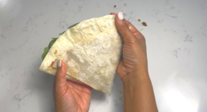 seal the edge by adding the refried to glue it or add cheese 