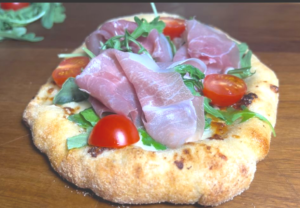 Top white pizza with Prosciutto and Arugula