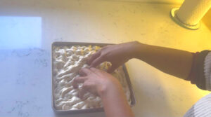 Spread the dough around the pan with your finger tips