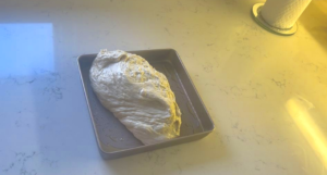 transfer the dough into greased baking pan.